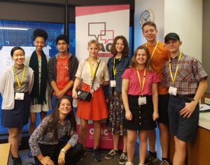 Image of young people standing and kneeling in front of a Youth Advisory Group OVIC banner. 